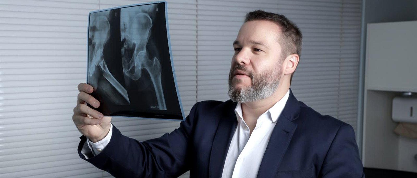 Dr. Ricardo lendo um exame de imagem contra a luz