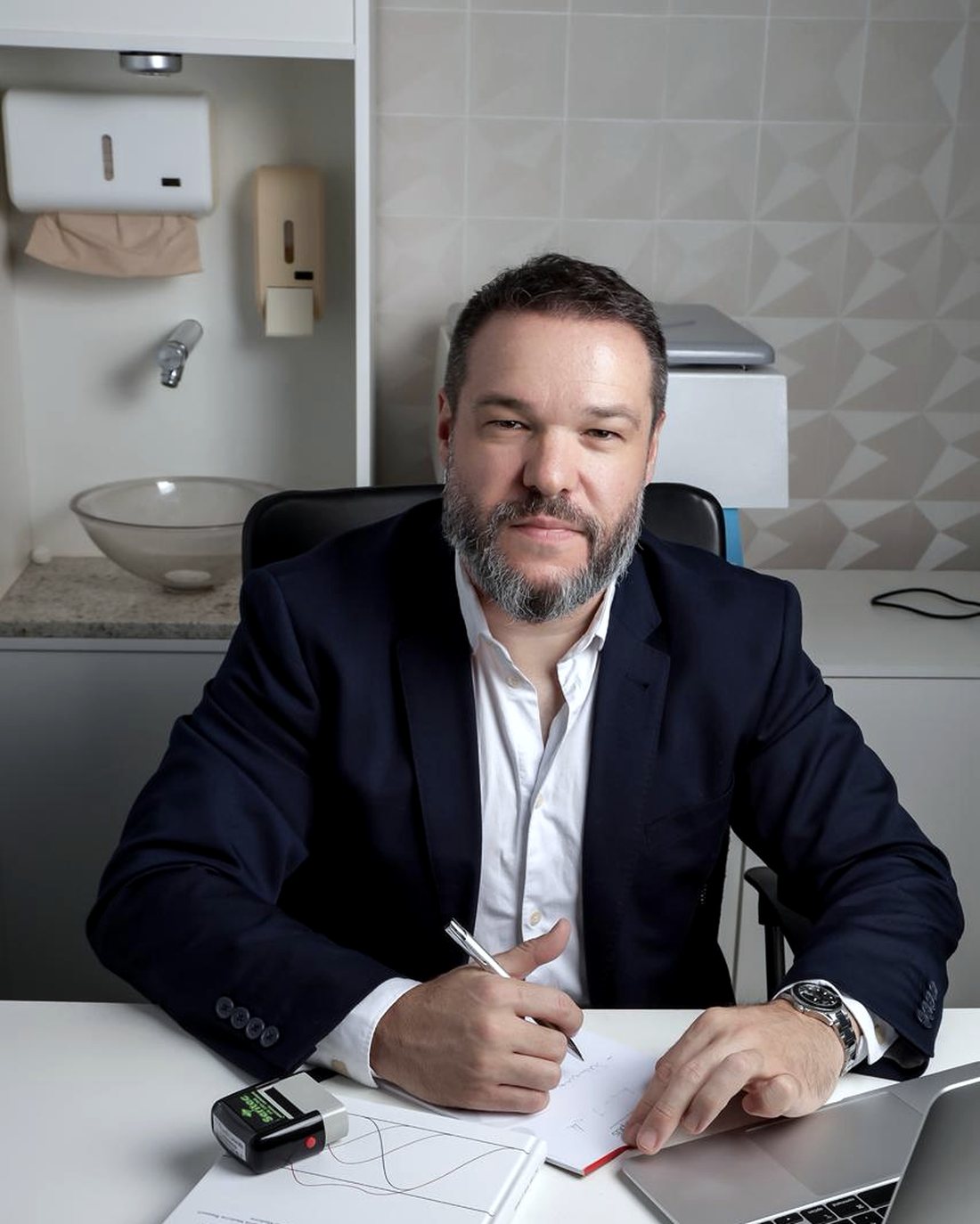 Dr. Ricardo Lazarotto no consultório, anotando a conduta antes do procedimento